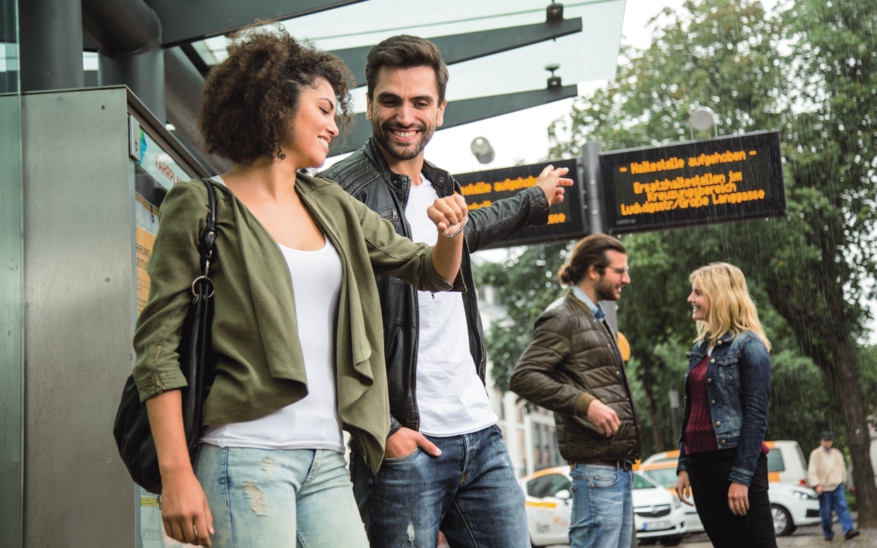 Junge Menschen stehen bei Regen an einer Haltestelle der Mainzer Mobilität Junge Menschen stehen bei Regen an einer Haltestelle der Mainzer Mobilität