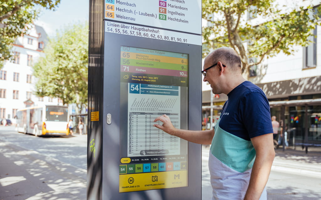Foto eines Mannes, der an einer MobiSäule einen Fahrplan anschaut