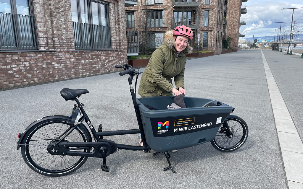 Foto einer Frau am Zollhafen, die gerade etwas in die Ladefläche eines Lastenrads gibt