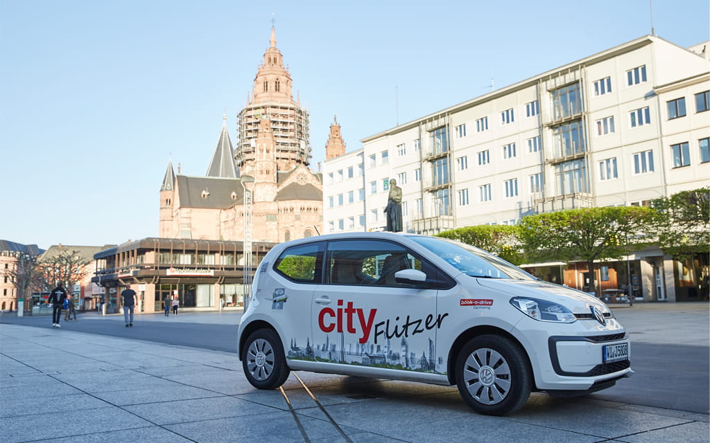 Ein Book N Drive Auto auf der Ludwigstraße mit dem Mainzer Dom im Hintergrund