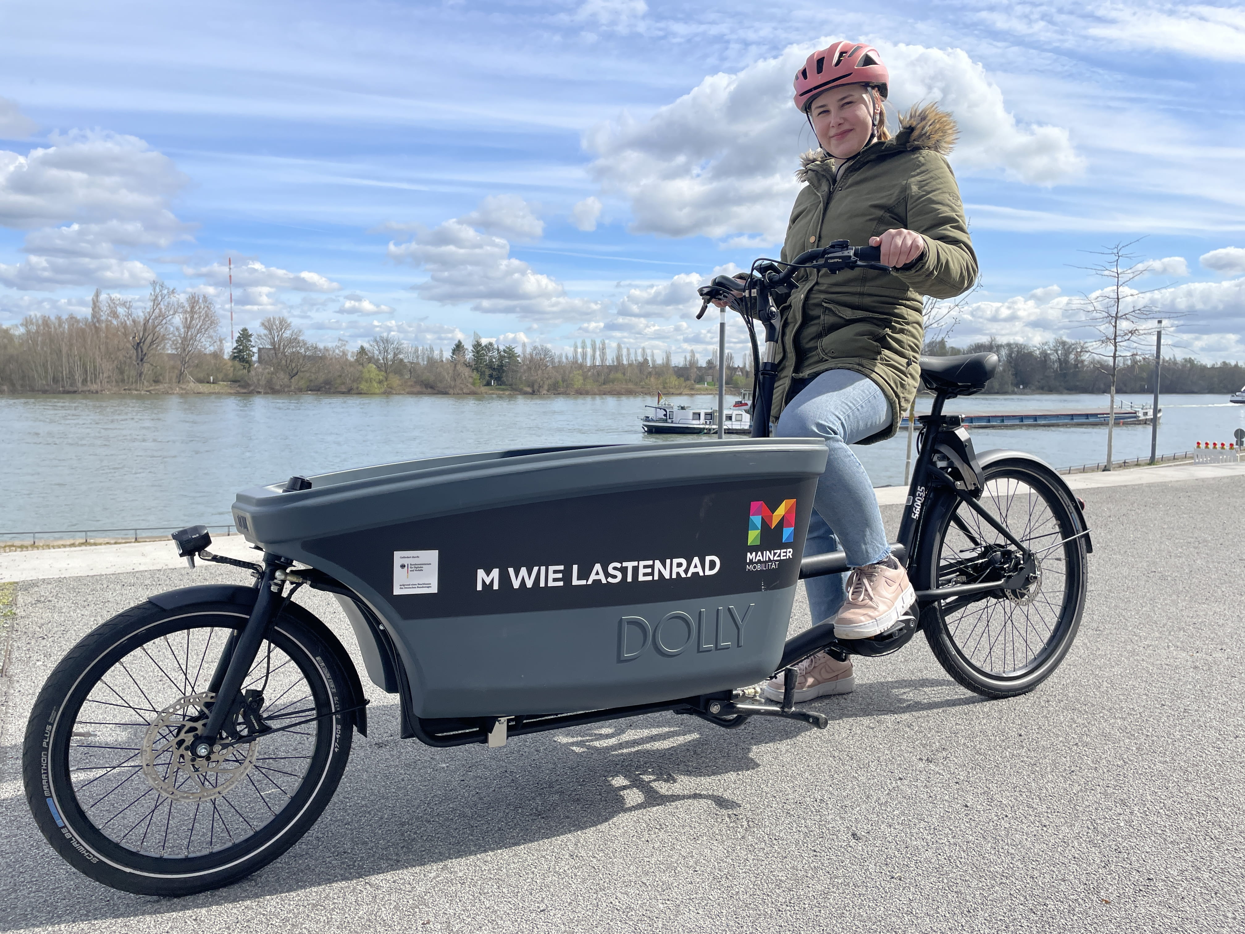 Lastenrad am Rhein mit Fahrerin