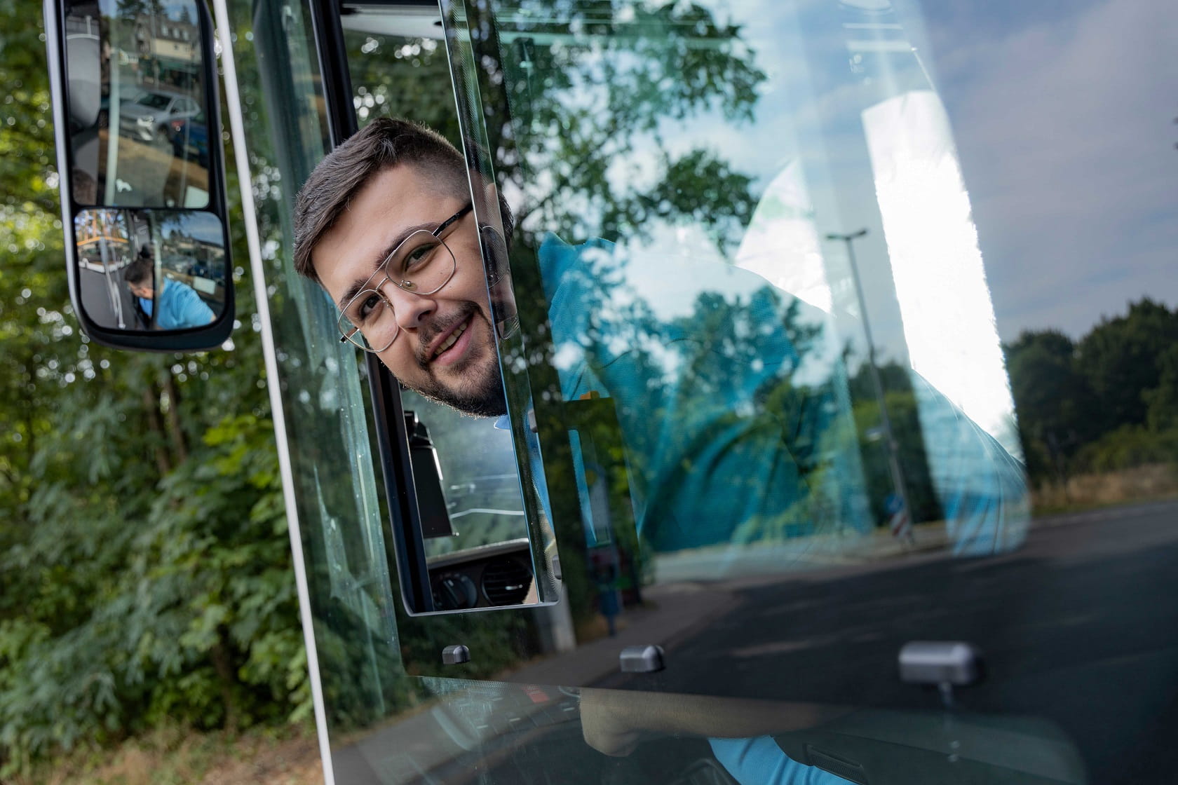 Busfahrer schaut nach hinten aus seinem Busfenster heraus. 