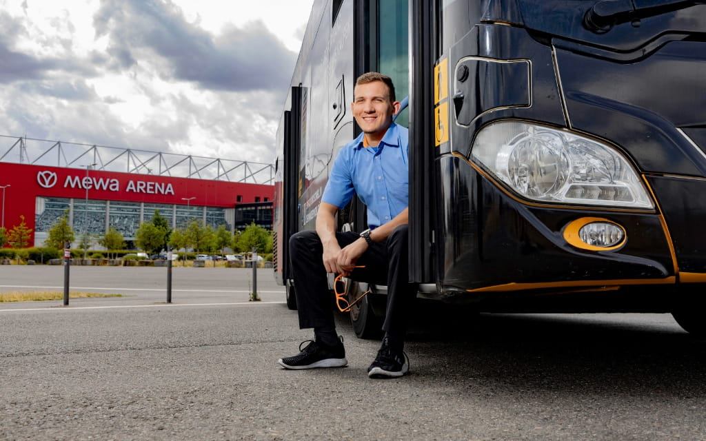 Foto eines Busfahrers, sitzend an einer Bustür