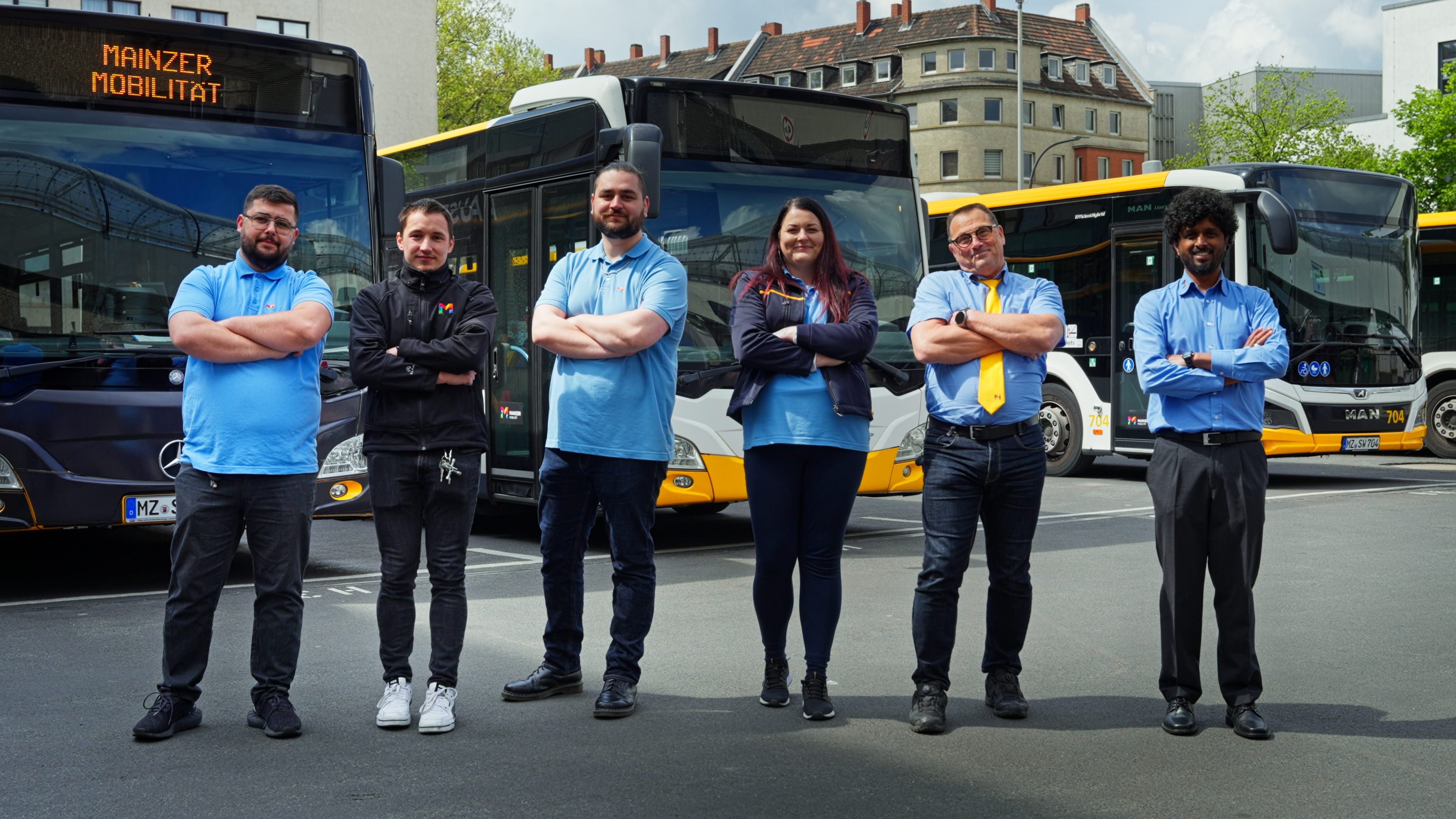 Bild von sechs Busfahrer/-innen vor Bussen