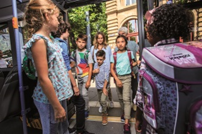 Eine größere Menge Kinder betritt einen Bus
