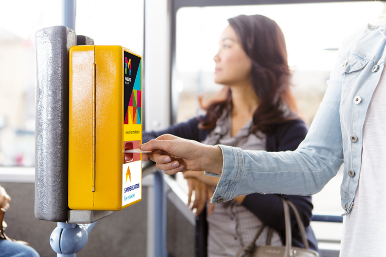 Eine Dame entwertet eine Sammelkarte im Bus