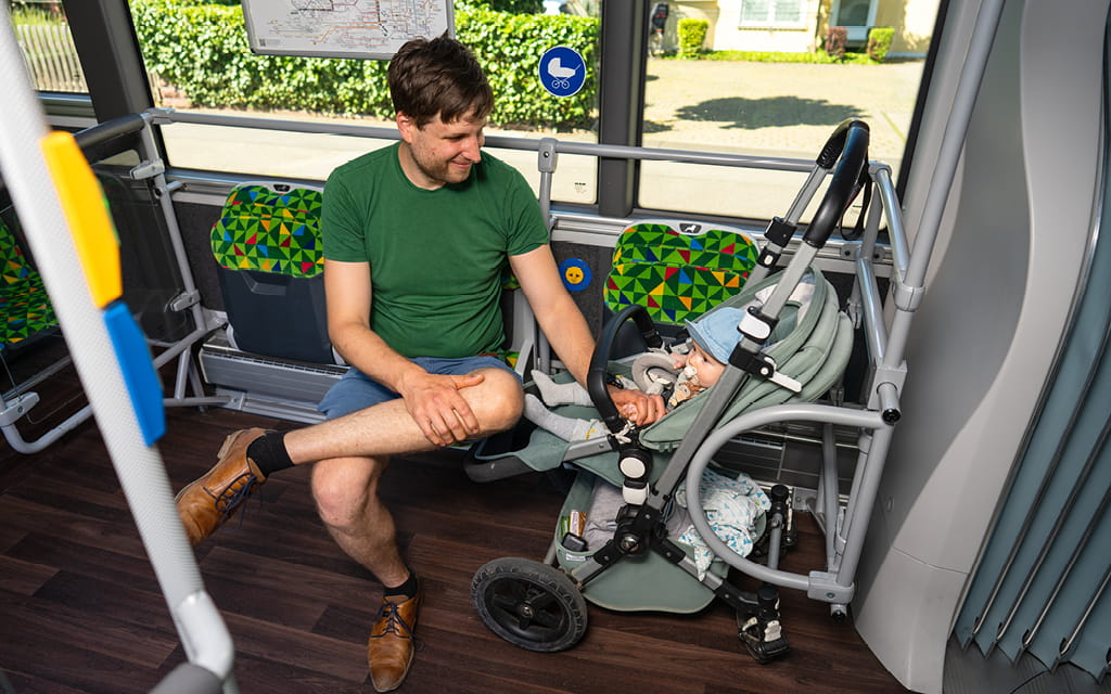 Foto von einem Mann im Bus mit Kinderwagen