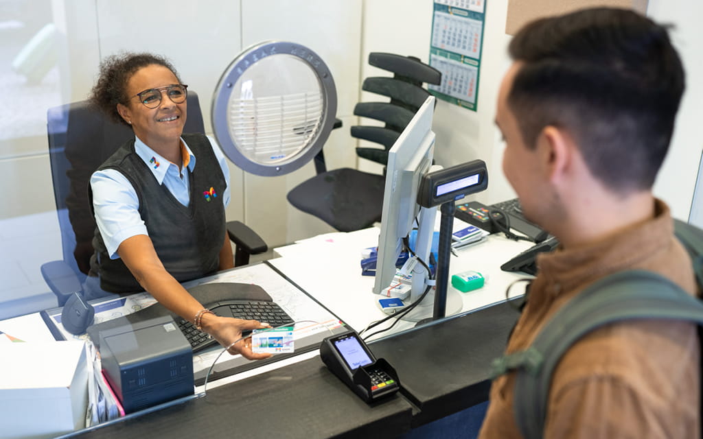 Foto eines Kunden am Kundencenter-Schalter bei einer Mitarbeiterin