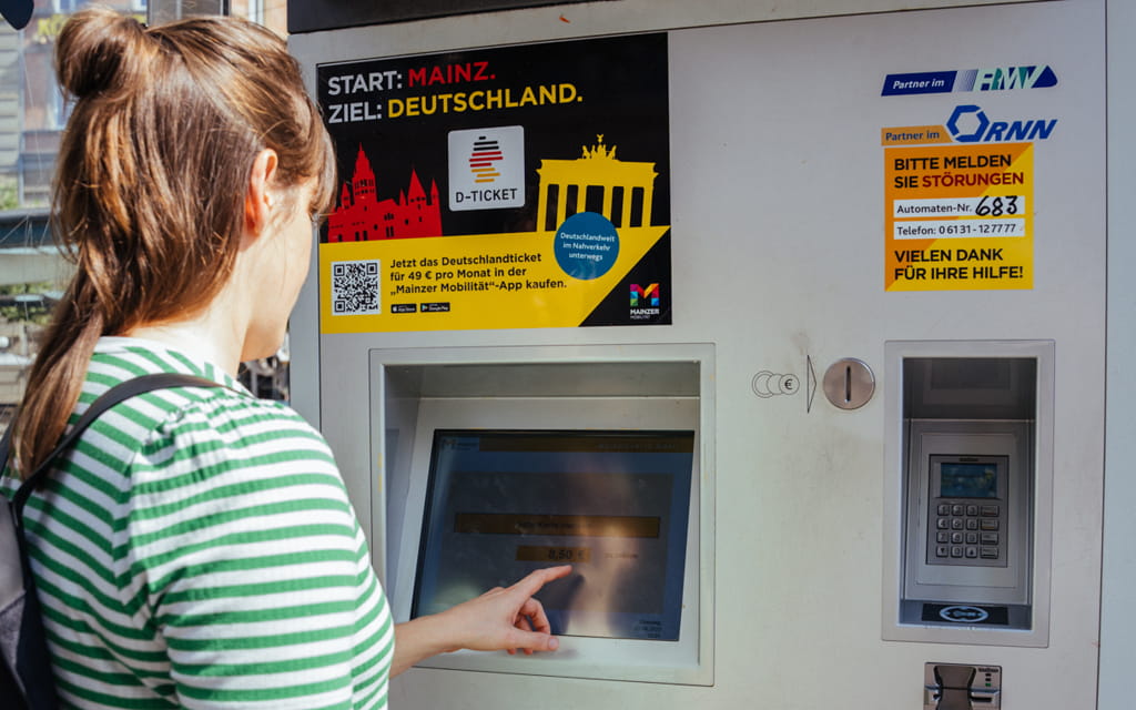 Foto einer Frau vor dem Fahrkartenautomaten